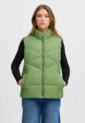 Gilet imbottito verde a trapunta con colletto alto, chiusura con zip e tasche laterali. Il tessuto ha una finitura liscia e opaca.