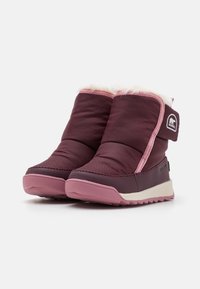 Bottes imperméables violettes et roses avec garniture en fausse fourrure, bout rond et semelle en caoutchouc texturée pour une meilleure adhérence. Comprend un patch logo sur le côté.