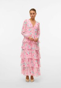 Lång klänning i rosa blommönster med lagerpåsar, genomskinligt tyg, djup V-ringning, långa ärmar och en svävande silhuett. Har subtila blå detaljer.