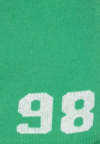 Zelená pletená látka se silnými bílými čísly "9" a "8". Textura je měkká a vzor je rovnoměrný po celé ploše.