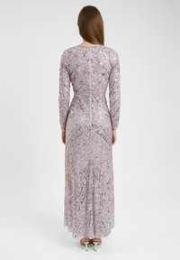 Langärmliges, enganliegendes Kleid in helllila, verziert mit silbernen Pailletten und filigranen Mustern. Verfügt über einen Reißverschluss im Rücken und einen ausgestellten Rock.