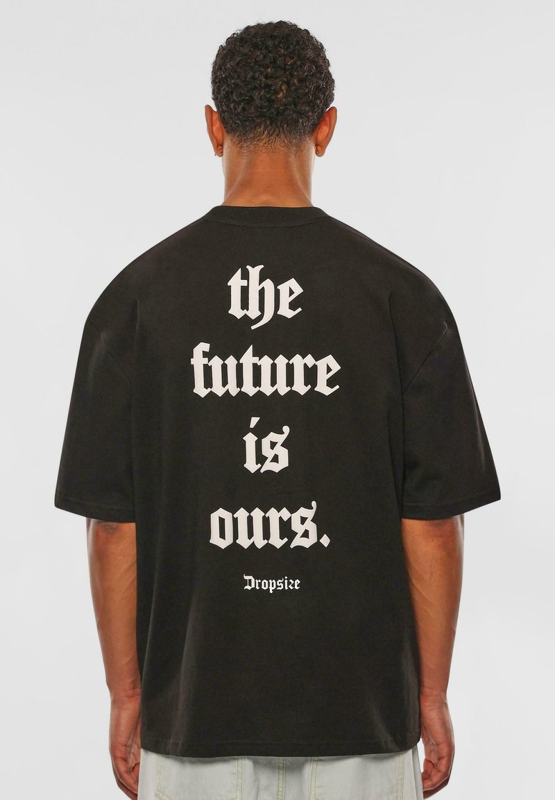 Black cotton t-shirt featuring bold white text on the back that reads “the future is ours.” and “Dropsize.” Loose fit with short sleeves.
