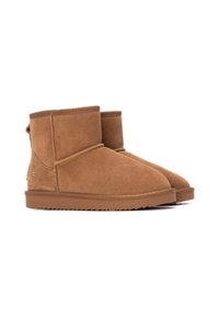 Botas de tobillo de ante marrón con puntera redonda y paneles laterales elásticos. Cuentan con una suela de goma texturizada y detalles de costura a lo largo de las costuras.