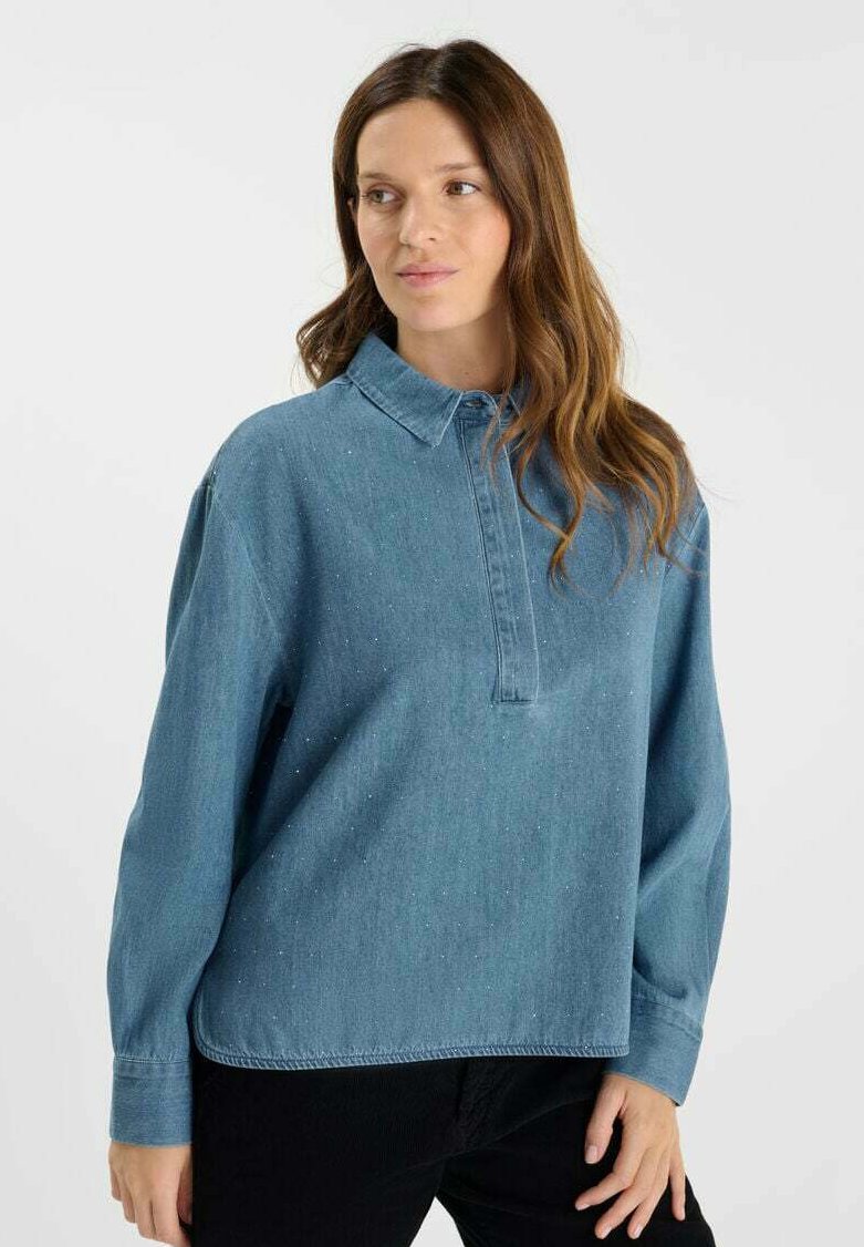 Lichtblauw denim overhemd met een kraag, lange mouwen en een halve knoopsluiting; zichtbare textuur en subtiele details door het hele shirt.
