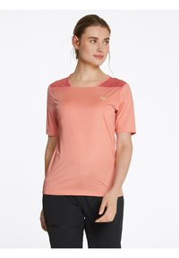 Camiseta ligera de manga corta en suave color coral; textura lisa con un patrón sutil; presenta un escote redondeado y un pequeño logotipo.