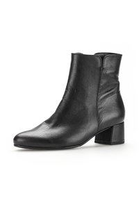 Bottine chelsea en cuir noir avec un bout rond, une texture lisse, une fermeture éclair sur le côté et un petit talon carré.