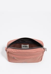 Różowa nylonowa torba na zamek błyskawiczny z teksturowanym wnętrzem, przednią kieszenią i metką z logo. Posiada metalowe elementy i gładką powierzchnię zewnętrzną.