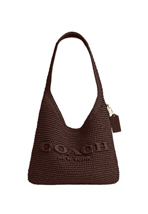 Tamno smeđa pletena torba za rame marke Coach s širokom ručkom, utisnutim logotipom sprijeda i pričvršćenom kožnom oznakom na zlatnom lancu.