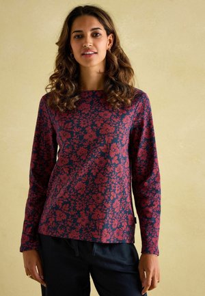 Langarmoberteil in Dunkelblau mit roten Blumenmustern. Rundhalsausschnitt, weicher Stoff und leicht lockere Passform. Hat keine sichtbaren Beschläge.