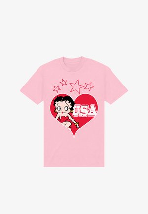 Rosa T-Shirt mit einem roten Herzmotiv, das eine Zeichentrickfrau in einem roten Kleid zeigt, mit dem Schriftzug "USA" und fünf roten Sternen über dem Herz.