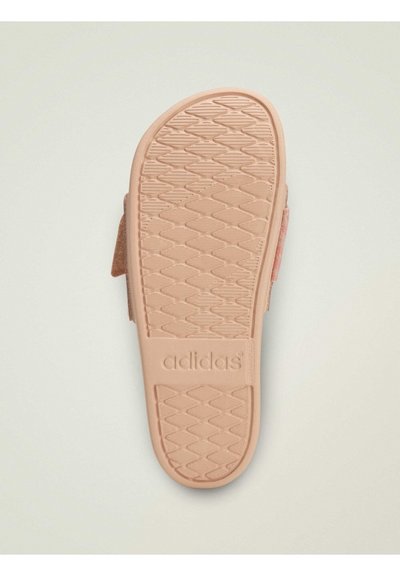 Chaussure Adidas avec une semelle extérieure en caoutchouc rose texturée présentant un motif géométrique et un détail de marque. Bride en velcro sur le côté.