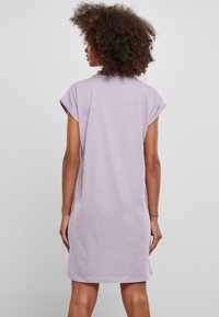 Robe t-shirt oversized lilas avec des manches courtes, en coton doux, décolleté arrondi et coupe décontractée tombant jusqu'à mi-cuisse.