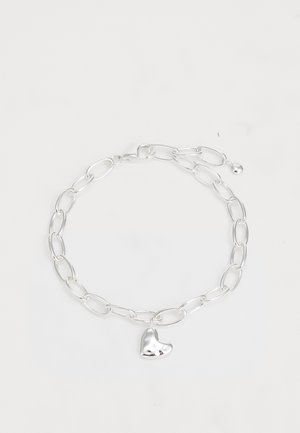Pulsera de cadena de plata con eslabones ovalados alargados y un colgante en forma de corazón pulido. Textura suave y acabado brillante.