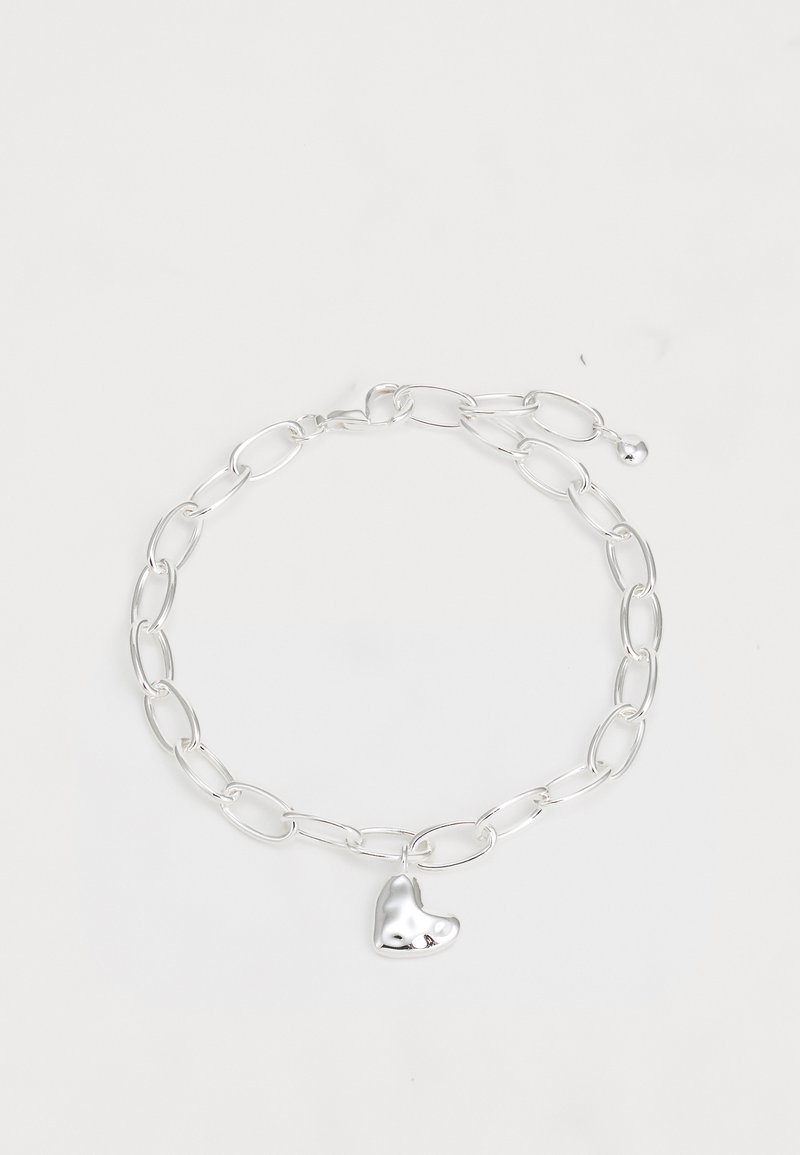 Hõbedane kett käevõru, millel on piklikud ovaalsed lingid ja poleeritud südamevormine ripats. Sile pind ja läikiv viimistlus.