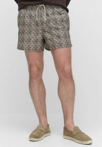 De shorts hebben een geometrisch diamanten patroon in bruin en crème, gemaakt van lichte stof; elastische tailleband met een koord.