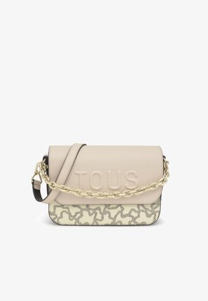 Sac à épaule en cuir beige avec logo "TOUS" en relief. Base crème avec un motif décoratif gris, fini avec une chaîne dorée.