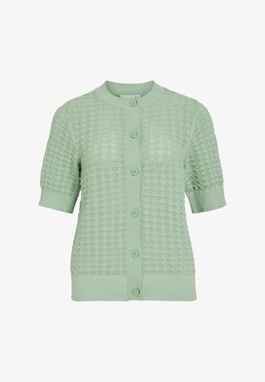 Īsa piedurkņu kardigāns gaiši zaļā trikotāžas audumā, ar atvērtu dimanta rakstu, ribotām aprocēm un piecām priekšējām pogām.