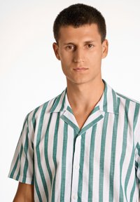 Lyhythihainen paita, jossa on vihreät ja valkoiset pystysuorat raidat, napitettava etuosa, pehmeä materiaali ja lovellinen kaulussuunnittelu.