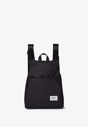 Schwarzer Rucksack mit vorderer Reißverschlusstasche, zwei verstellbaren Schultergurten, Tragegriff oben und weißem KCB-Logo-Patch vorne unten rechts.