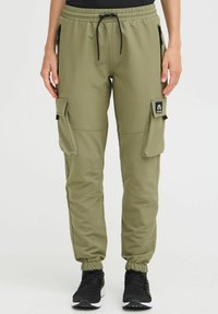 Olive green cargo pants made of stretch fabric, featuring zip pockets, an elastic waistband, and ribbed cuffs. Detailed with logo patch.