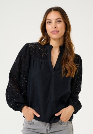 Schwarze Bluse mit Spitzen-Puffärmeln, einem Schlitzkragen und einem strukturierten Körper. Verfügt über ein gerafftes Design und einen lockeren Schnitt.
