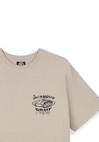 Camiseta de algodón beige con cuello redondo y mangas cortas. Presenta un gráfico negro de un tanque y la palabra "INFAMOUS GRIMY" en texto goteante.