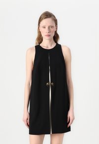 Vestido preto sem mangas com um decote alto, apresentando um accentuador central em dourado e um detalhe vertical em prata. Textura suave.