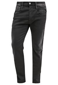 Vaqueros negros de corte ajustado, hechos de denim suave, con cinco bolsillos, un botón de metal y un ligero desvanecimiento para un aspecto desgastado.