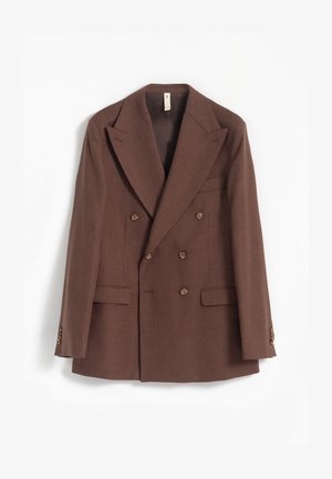 Blazer marrón de doble botonadura con solapas amplias, seis botones, dos bolsillos frontales de solapa y un bolsillo en el pecho sobre un fondo blanco.