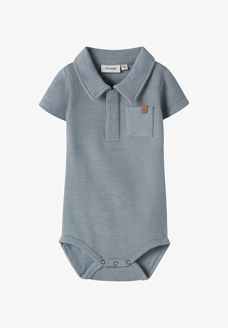 Jasnoniebieski krótki kombinezon niemowlęcy z teksturowanej tkaniny, małą kieszonką na piersi, kołnierzykiem oraz zapięciami na zatrzaski w kroku.