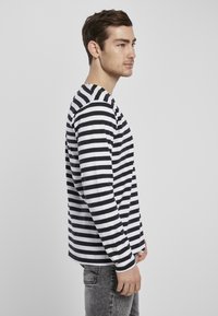 Langsleeve shirt van katoen, met zwart-witte horizontale strepen, een ronde hals en een relaxte pasvorm. Draag het met grijze denim broek.