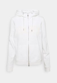 White zip-up hoodie made of soft fabric, featuring a hood, drawstrings, and front pockets. "GANT" is embroidered in light beige on the chest.