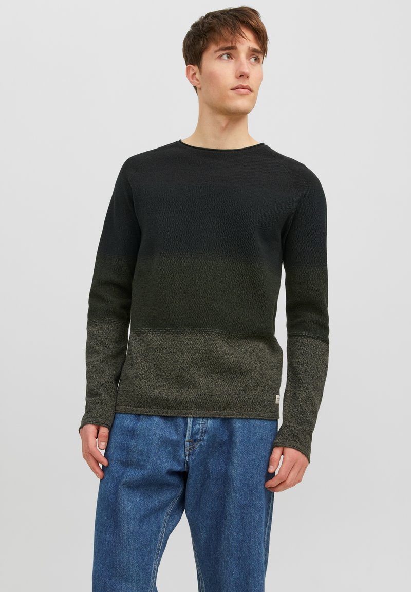 Donkergroene naar zwarte gradient gebreide trui met lange mouwen, ronde hals en ribgebreide boorden. Het combineren met blauwe jeans maakt de look compleet.