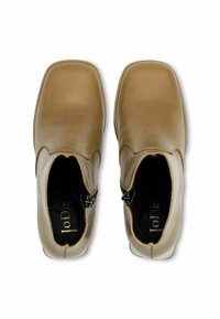 Bruņurupuču ādas potīšu zābaki ar kvadrātu purngalu un sānā esošām rāvējslēdzēju aizdares. Gluda tekstūra ar minimālistisku dizainu un diskrētu dūrienu akcentu augšdaļā.