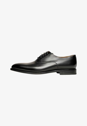 Schwarze Leder-Schnürschuhe mit glatter Oberfläche, runder Zehenpartie und niedrigem, gestapeltem Absatz. Mit dezenten Nähten und einem eleganten Design.