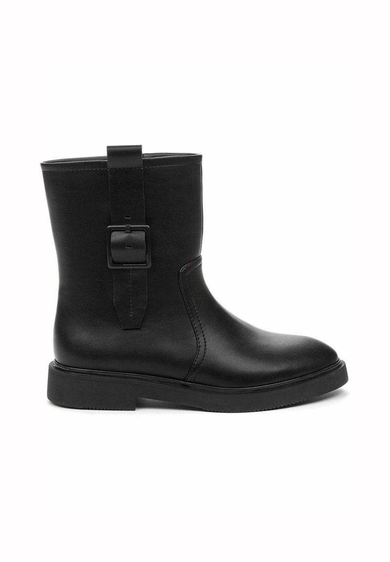 Botte en cuir noire mi-mollet avec bout arrondi, talon bas, semelle plate et bride décorative à boucle sur le côté extérieur.