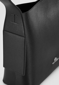 Borsa nera con superficie in pelle texturizzata, forma arrotondata e una tasca piatta sul lato. Presenta un sottile dettaglio del logo nella parte inferiore.