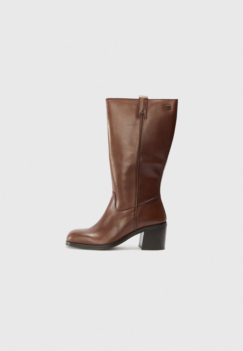 Brauner Lederstiefelette bis zur Wadenmitte mit Blockabsatz, runder Zehenform und einem kleinen Metall-Logo nahe der Oberseite an der Außenseite.
