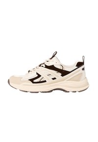 Baskets de sport avec un dessus crème, accents brun foncé, maille respirante, superpositions texturées et une semelle rembourrée avec des rainures.