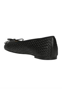 Scarpa piatta nera con tomaia in pelle intrecciata, punta arrotondata e accentuata da un fiocco. Tacco basso e superficie liscia. Luccichio sottile sulla superficie.