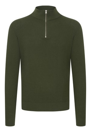 Žalios spalvos megzta palaidinė su aukštu koloriumi ir ketvirtadalio ilgio užtrauktuku. Pasižymi tekstūruota paviršiumi ir bangomis prie rankovių ir apatinės dalies.