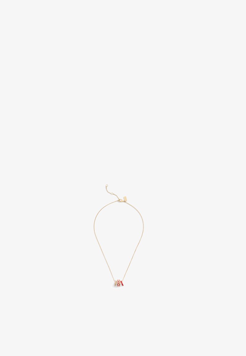 Collier en plaqué or avec une chaîne fine et un petit pendentif décoratif rouge et blanc. Design simple avec un fermoir ajustable.