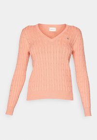 Pull rose en maille torsadée à col en V avec manches longues, poignets et ourlet côtelés, orné d'un petit logo brodé sur la poitrine.