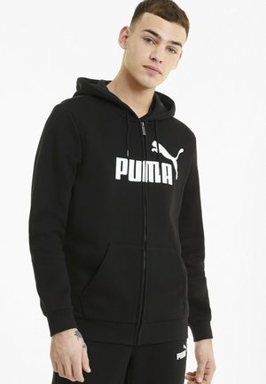 Felpa nera con zip realizzata in tessuto morbido, con un grande logo bianco Puma sul petto e tasche a marsupio. Cappuccio regolabile con lacci.