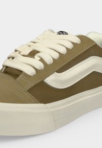 Καφέ και λευκό αθλητικό Vans με λευκά κορδόνια, σχεδιασμό κύματος στο πλάι και παχιά υφασμένη λευκή λαστιχένια σόλα.