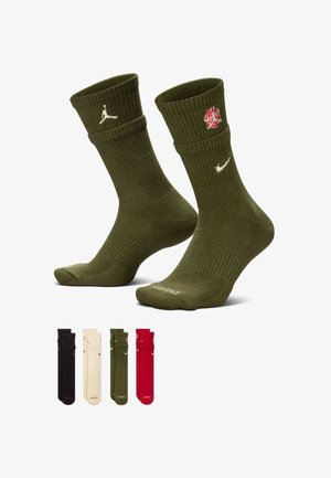 To olivengrønne crew-sokker med hvite Nike- og Jordan-logoer, rød roseemblem, og fire ekstra par i svart, beige, oliven og rød under.