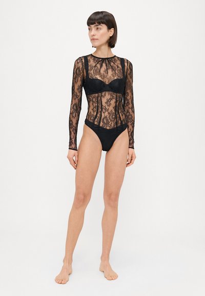 Črn čipkast bodysuit z dolgimi rokavi, prozornim cvetličnim vzorcem, visokim ovratnikom in oprijetim krojem. Vključuje vgrajen modrček in ujemajoče se hlačke.