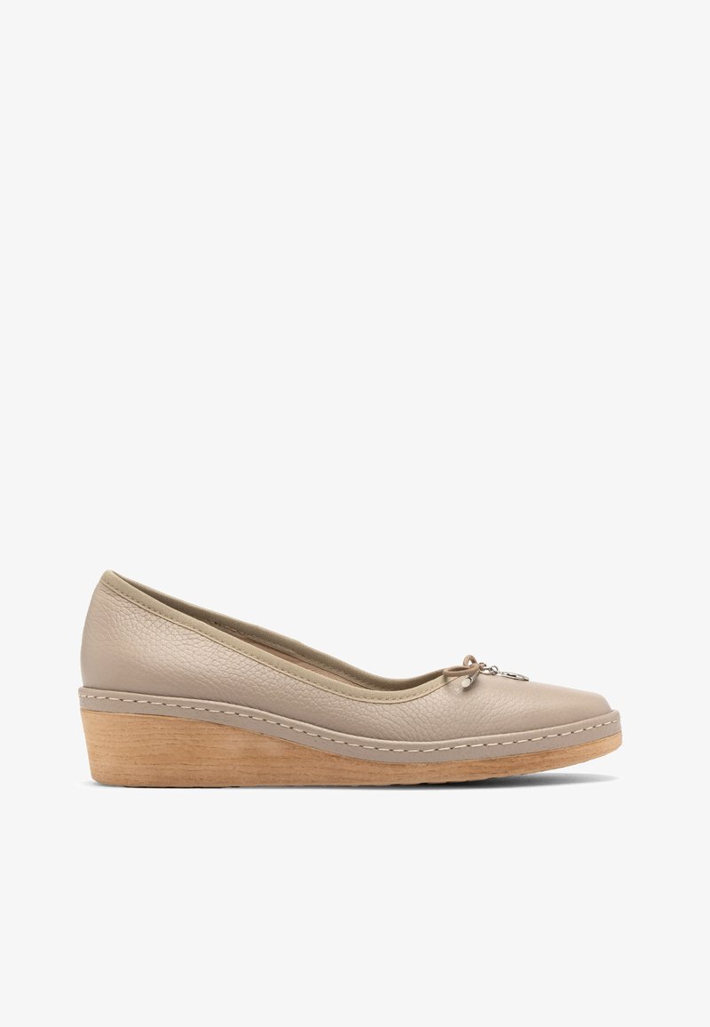 Chaussure compensée en cuir beige avec un bout arrondi, une surface texturée, et un nœud décoratif avec un petit charme à l'avant. Talon en bois clair.