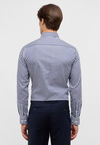 Marineblau- und weiße gestreifte Langarmbluse mit taillierter Passform, geknöpften Manschetten und einem spitzen Kragen. Glatte Stoffoberfläche.