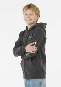 Mørkegrå zip-up hoodie med kængurulommer, ribbede manchetter og karakteristiske grønne grafiske detaljer på venstre ærme. Blød stofoverflade.